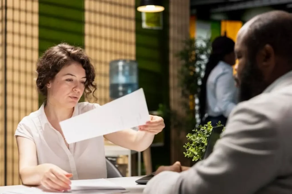 HR professional handing over the paper with job benefits package